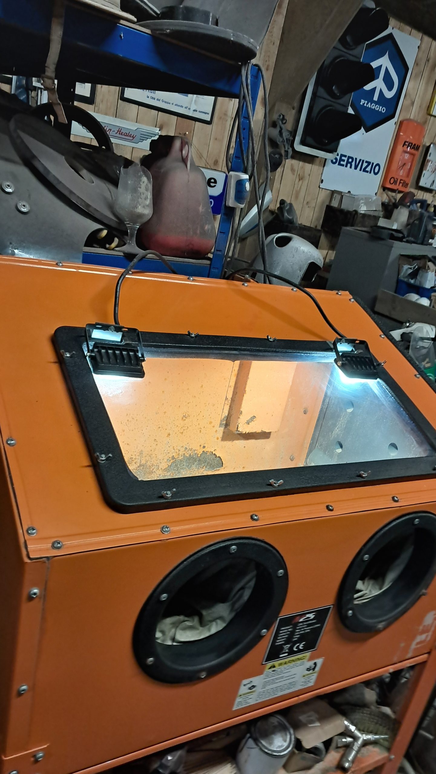 Sandblasting cabinet with LED work lights in a workshop setup, ready for small parts cleaning and restoration.